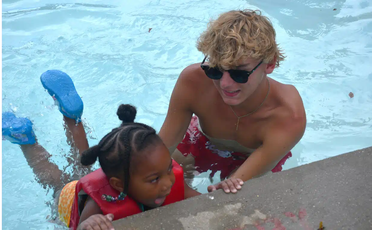 lifeguard teaching girl to swim