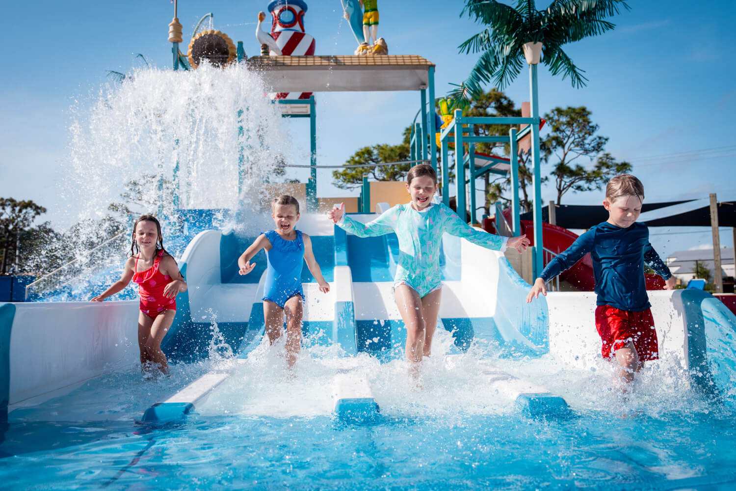 kids run on the water slide at shipwreck